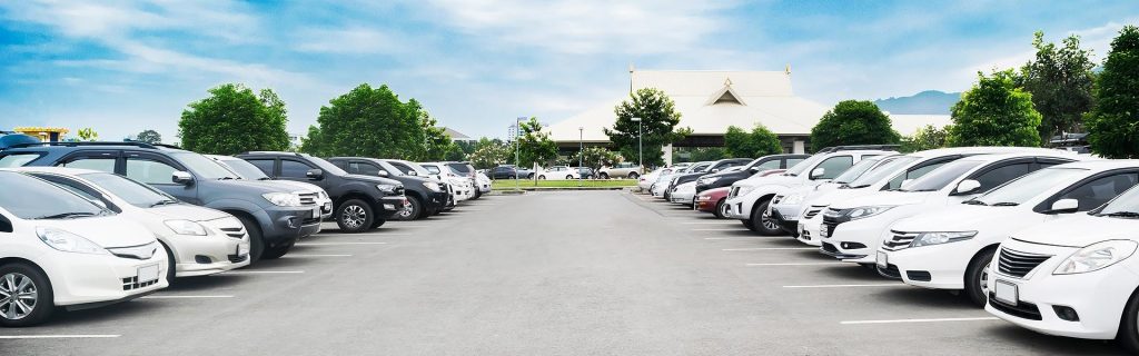 A large parking lot filled with rows of parked cars.