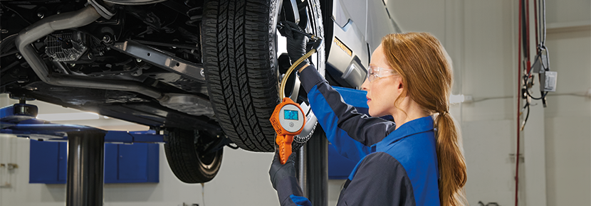 A Subaru technician checking tire pressure. | Grand Forks Subaru in Grand Forks ND