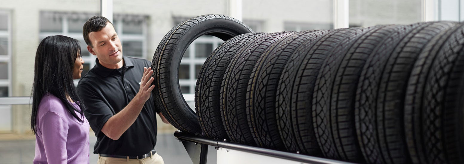Subaru service representative showing customer a tire. | Grand Forks Subaru in Grand Forks ND