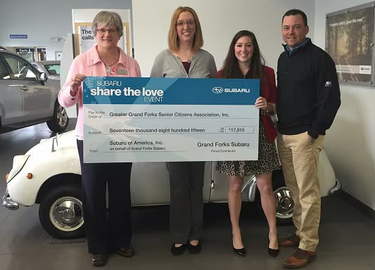 share the love group holding big check Grand Forks Subaru in Grand Forks ND