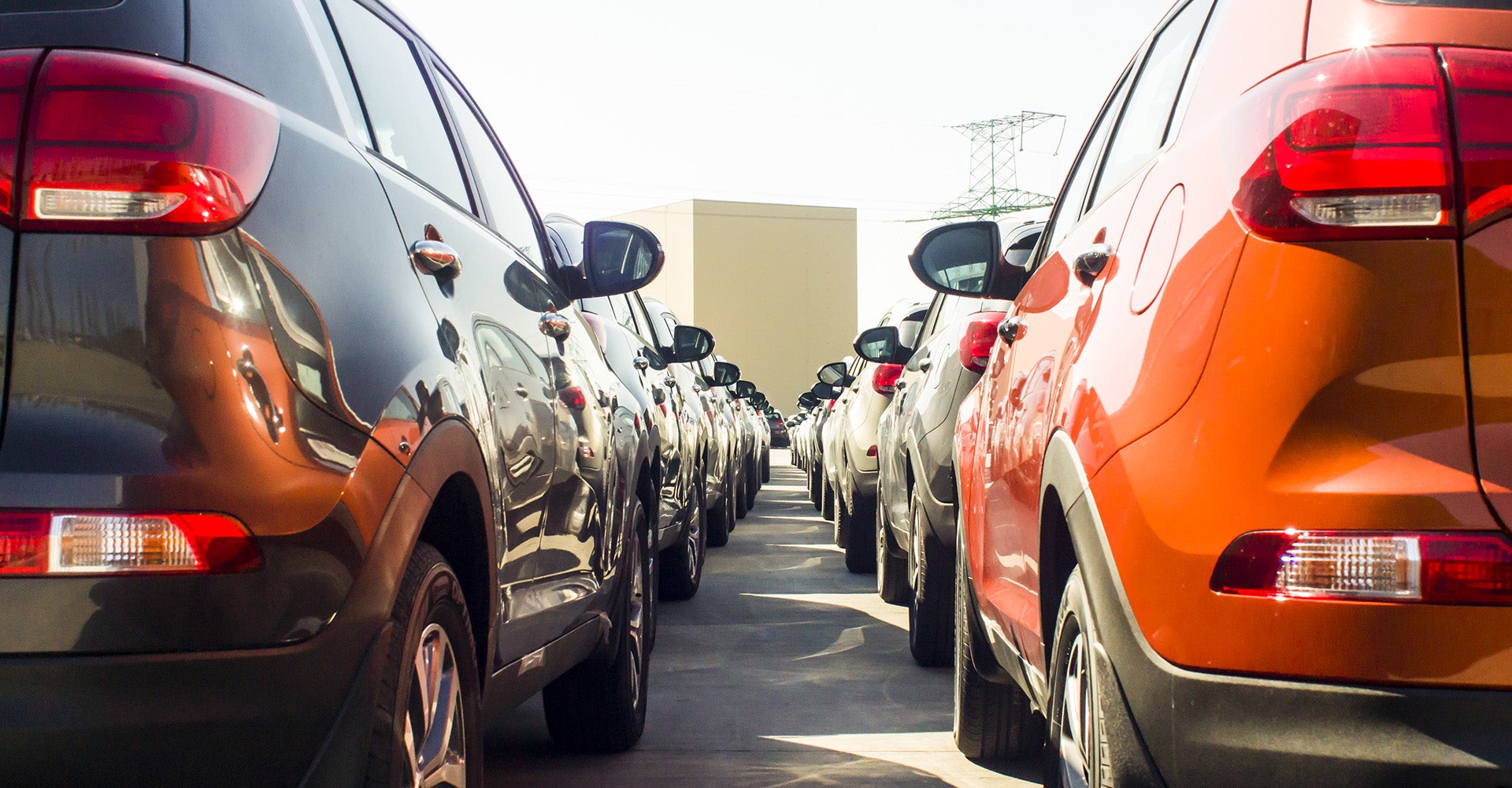 Rows of cars parked closely together in a lot.